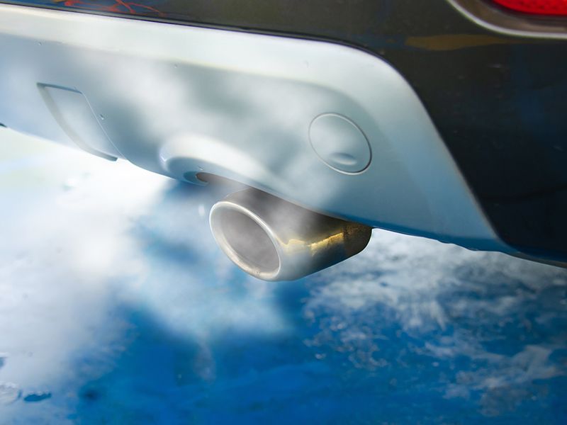 Tubo de escape del coche echando humo.